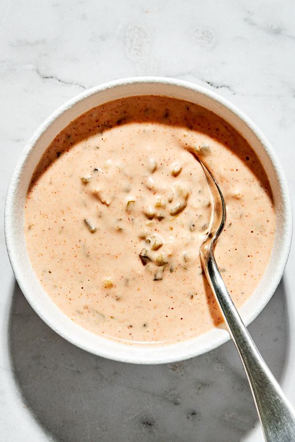 a bowl of thousand island dressing made with mayo, ketchup, relish, paprika, lemon juice, onion, garlic, salt & pepper