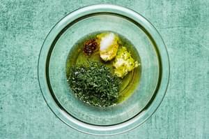 vinegar, garlic, dill, olive oil, stone ground mustard, salt and pepper in a mixing bowl to make dressing for tomato salad