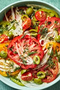 Tomato Salad made of tomatoes, fennel, olives, vinegar, garlic, dill, olive oil, stone mustard, salt & pepper in a bowl