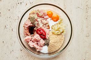 ground turkey, onion mixture, bread crumbs, milk, tomato paste, seasonings, Worcestershire & eggs in a bowl ready to combine
