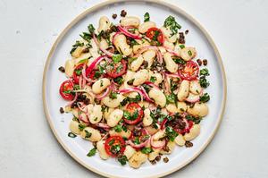 homemade white bean salad with anchovy vinaigrette made with butter beans, tomatoes, parsley, and capers on a plate