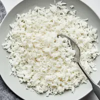 homemade fluffy white rice in a serving bowl with a spoon