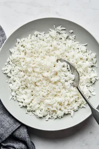homemade fluffy white rice in a serving bowl with a spoon
