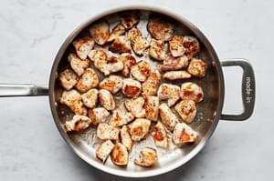 chicken seasoned with salt, pepper, garlic powder, onion powder and oregano being cooked in a skillet