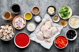 chicken thighs, mushrooms, peppers, red wine, tomatoes, olives, basil, Parmesan, and spices in prep bowls