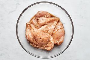 raw chicken cutlets tossed in olive oil, balsamic vinegar, garlic, salt, pepper and Italian seasoning in a large mixing bowl