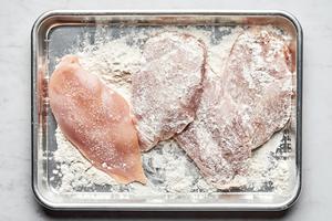4 chicken cutlets patted dry then seasoned with salt, being dredged in flour on a baking sheet