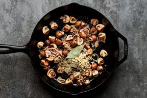 mushrooms, shallots and spices being cooked in a skillet for chicken marengo