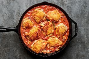 chicken marengo cooking in a skillet made with mushrooms, shallots, diced tomatoes, orange zest and spices