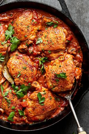 homemade chicken marengo topped with fresh parsley in a skillet made with mushrooms, shallots, diced tomatoes and spices