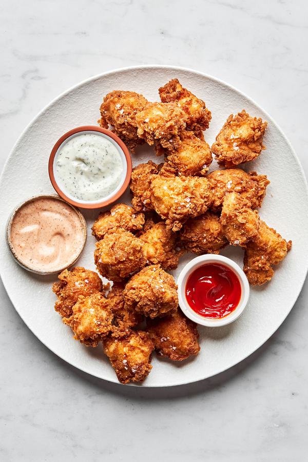 homemade chicken nuggets on a plate served with ranch, fry sauce and ketchup for dipping