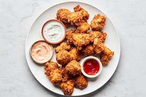 homemade chicken nuggets on a plate served with ranch, fry sauce and ketchup for dipping
