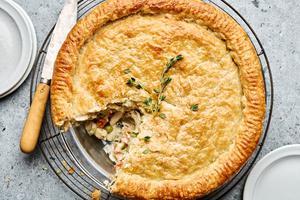 A golden-brown homemade chicken pot pie with a flaky crust, filled with chicken, vegetables, and creamy sauce