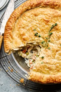 A golden-brown homemade chicken pot pie with a flaky crust, filled with chicken, vegetables, and creamy sauce