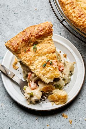 A slice of golden-brown homemade chicken pot pie with a flaky crust, filled with chicken, vegetables, and creamy sauce