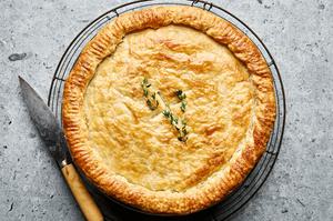A golden-brown homemade chicken pot pie with a flaky crust, filled with chicken, vegetables, and creamy sauce