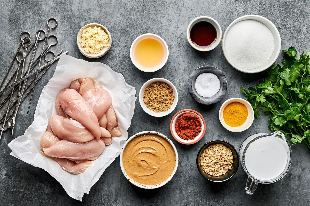 Measured Ingredients for chicken satay with peanut sauce arranged neatly, including chicken, spices and peanut butter