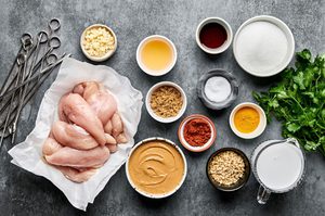 Measured Ingredients for chicken satay with peanut sauce arranged neatly, including chicken, spices and peanut butter