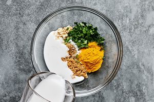 a bowl of marinade for chicken satay coconut milk, brown sugar, spices, and cilantro
