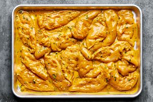 pounded raw chicken tenders covered in a coconut milk, turmeric marinade