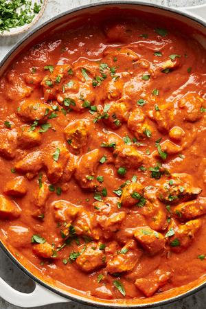 a pot of homemade chicken tikka masala sprinkled with cilantro