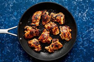 citrus chicken being cooked in a non stick skillet