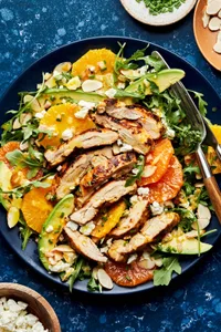 arugula drizzled with citrus dressing topped with chicken, avocado, feta, orange, almonds and chives