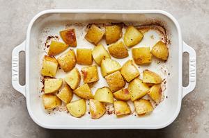roasted potatoes in a baking dish that were seasoned with salt and pepper