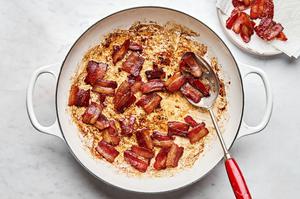 chopped bacon being cooked in a pan