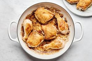 chicken thighs and drumsticks seasoned with salt being browned in a pan of bacon fat