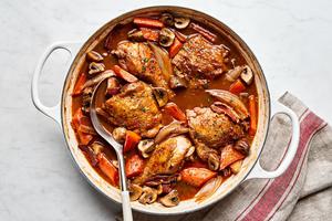 A pot of homemade coq au vin, with chicken, vegetables, and a rich red wine sauce simmering together.