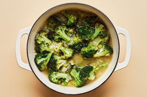 a soup pot with broccoli, chicken stock, and onions add garlic that have been cooked in butter and olive oil