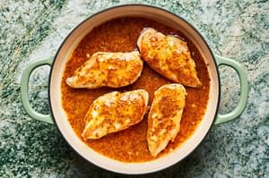 honey mustard curry sauce poured over browned chicken in a skillet
