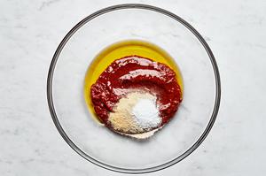 harissa, olive oil, salt, garlic powder, and onion powder combined in a glass bowl