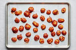 potatoes tossed with harissa, olive oil, salt, garlic powder, and onion powder on a baking sheet