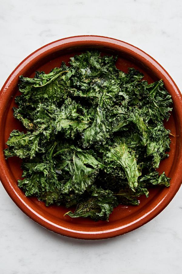 Crispy homemade kale chips, lightly seasoned and baked to golden perfection, arranged in a bowl for serving.