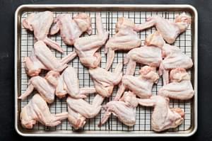 chicken wings that have been coated in egg whites on a wire rack on top of a baking sheet