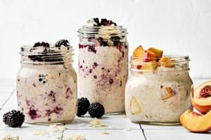 Three jars of overnight oats with various toppings: fruit, chia seeds, jam and coconut