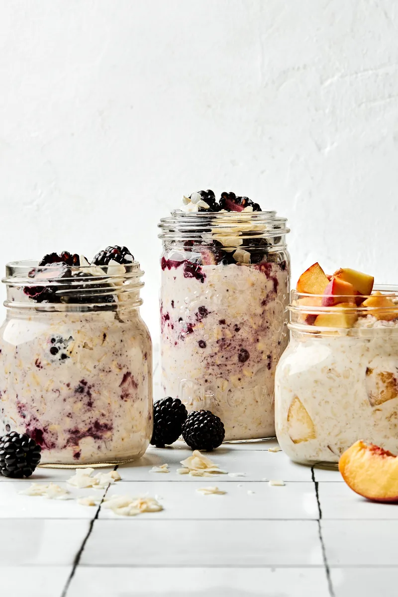 Three jars of overnight oats with various toppings: fruit, chia seeds, jam and coconut