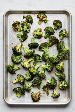 perfect roasted broccoli seasoned with olive oil salt and pepper on a baking sheet