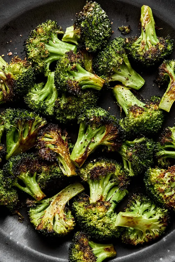 a bowl of perfect roasted broccoli seasoned with olive oil salt and pepper