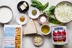 ingredients to make pink sauce parmesan, salt, pepper, garlic, onion, basil, butter, heavy cream and tortiglioni pasta