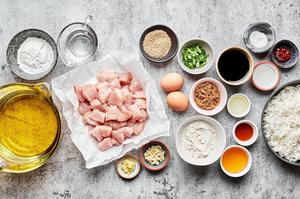 ingredients to make homemade sesame chicken in prep bowls: vegetable oil, chicken, soy sauce, sesame oil & chili paste
