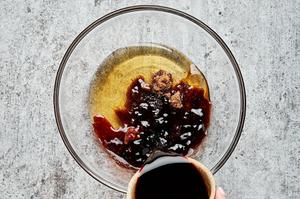 soy sauce, rice vinegar, sesame oil, honey, brown sugar, and Sambal oelek being mixed together in a glass bowl