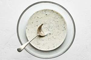 dill dressing in a bowl made with mayonnaise, yogurt, olive oil, garlic, dill, vinegar, salt, pepper, and sugar.