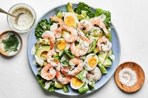 shrimp and avocado salad topped with hard boiled eggs, homemade dill dressing and flaky salt