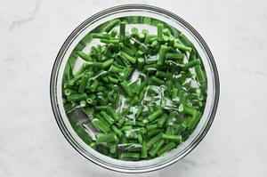 blanched green beans in a large bowl of ice water