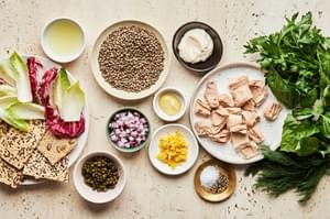 lentils, tuna, mayo, dijon, lemon zest & juice, spices, fresh herbs, red onion, capers crackers and endive in prep bowls