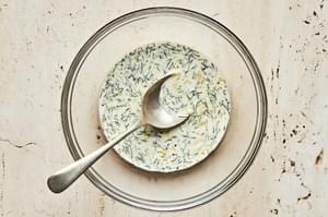 dressing in a glass bowl made with mayonnaise, Dijon, lemon zest, lemon juice, salt, pepper, and dill