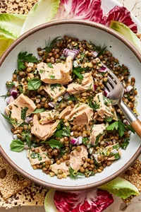 tuna lentil salad in a bowl made with lentils, tuna, mayo, dijon, lemon zest & juice, spices, fresh herbs, red onion & capers
